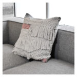 Funda con cojín cuadrada Antología color blanco y rosa con tejido artesanal decorativo, ubicada sobre sofá gris, foto plano detalle. All Star muebles