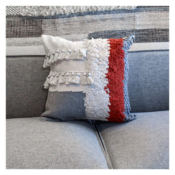 Funda con cojín cuadrado Antología multicolor con tejido artesanal decorativo, ubicada sobre sofá gris en ambiente minimalista, foto plano americano. All Star muebles