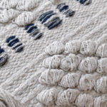 detalle funda con cojín Antología 50 con textura detalles tejidos artesanales decorativos, en tela blanca y azul primer plano. All Star decoración