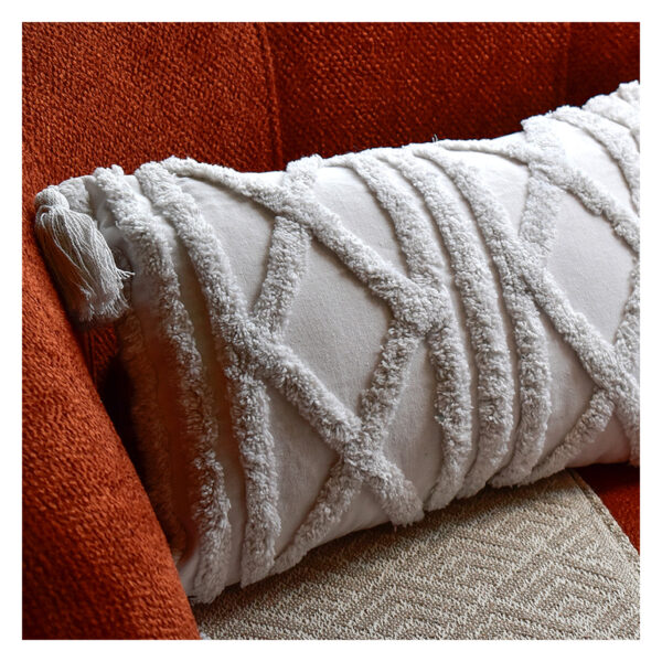 Funda con cojín rectangular Rustic color blanco con textura afelpada, ubicada sobre sofá rojo con una manta blanca complementaria, foto plano detalle. All Star muebles