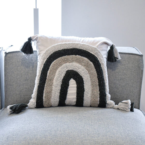 Funda con cojín Rustic multicolor con textura afelpada, ubicada sobre sofá gris en ambiente minimalista, foto plano americano. All Star muebles