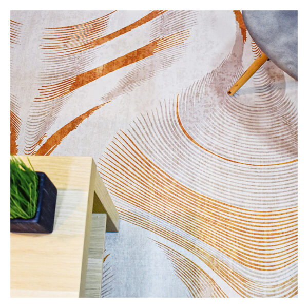 Fotografía plano detalle de tapete geométrico orgánico en tonos grises con naranja, con una silla de patas en madera encima. All Star decoración.