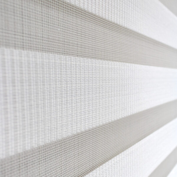 Detalle de persiana enrollable tipo zebra en tono blanca con textura de tela y acabado brillante. All Star decoración