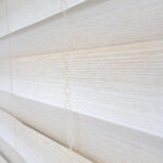 Detalle de persiana enrollable tipo zebra en tono ivory con textura de tela de enlazada vertical. All Star decoración