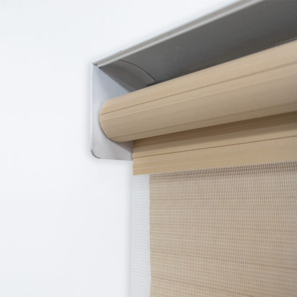 Detalle del mecanismo de una persiana enrollable tipo zebra con cadena plástica blanca y soporte lateral, textura de tela. All Star decoración