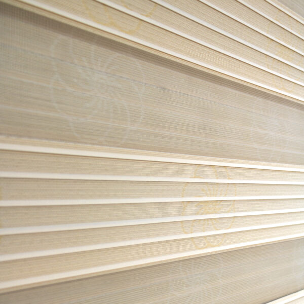 Detalle de persiana enrollable tipo zebra en tono beige con textura de tela de flores. All Star decoración