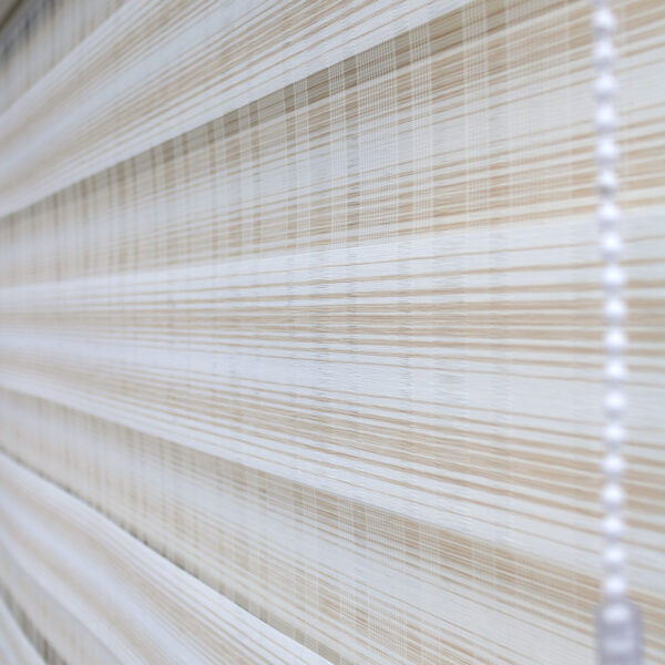 Detalle de persiana enrollable tipo zebra en tonos beige y blanco con textura de tela. All Star decoración
