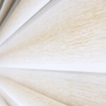 Detalle de persiana enrollable tipo zebra en tonos beige y blanco con textura de tela. All Star decoración