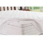 protector de colchón blanco acolchado ajustable puesto sobre colchón semi destapado en ambiente moderno. Muebles All Star