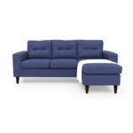 Sala en L Cielo con puff intercambiable tapizada en color azul, capitoneado en espaldar, con manta decorativa color blanca y patas en madera tono envejecido al 100% torneadas vista de frente. Muebles All Star