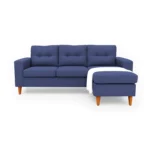 Sala en L Cielo con puff intercambiable tapizada en color azul, capitoneado en espaldar, con manta decorativa color blanca y patas en madera tono envejecido al 50% torneadas vista de frente. Muebles All Star