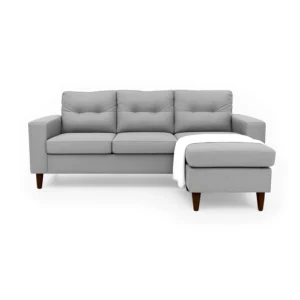 Sala en L Cielo con puff intercambiable tapizada en color gris, capitoneado en espaldar, con manta decorativa color blanca y patas en madera tono envejecido al 100% torneadas vista de frente. Muebles All Star