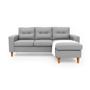 Sala en L Cielo con puff intercambiable tapizada en color gris, capitoneado en espaldar, con manta decorativa color blanca y patas en madera tono envejecido al 50% torneadas vista de frente. Muebles All Star